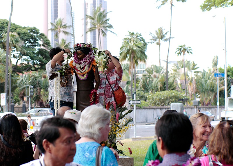 Bronze sculpture of Patsy T. Mink draped with several colorful lei