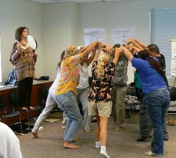 Classroom teachers standing in a circle with upraised arms