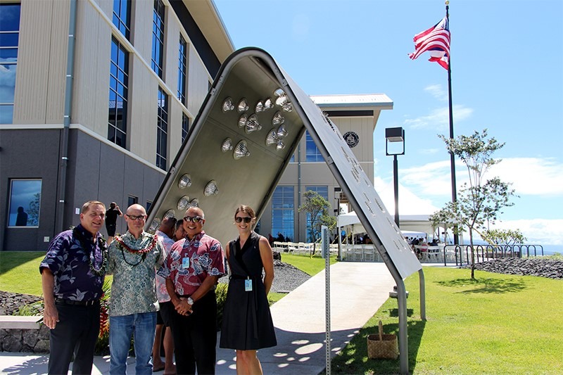 People standing in front of the "Creating Kamaaina" sculpture.