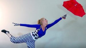 Janet Carafa miming being pulled along by an umbrella