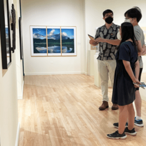Three people in a museum gallery.